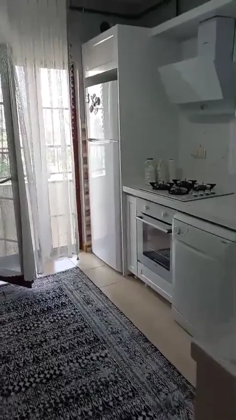 Teslim edilmiş beyaz mutfak dolapları ve mermer tezgâh
